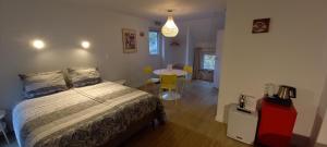 a bedroom with a bed and a table with chairs at B&B Les Lits de Nohaipré in Rendeux