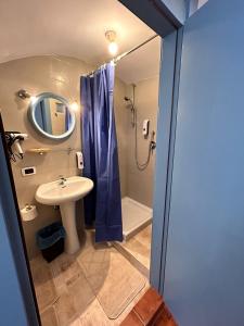 ein Badezimmer mit Waschbecken und Dusche mit Spiegel in der Unterkunft GEOMETRIC BLUE in Casamassima + 9 Fotos