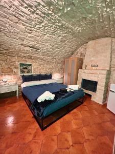 ein Schlafzimmer mit einem Bett in einem Steinzimmer in der Unterkunft GEOMETRIC BLUE in Casamassima