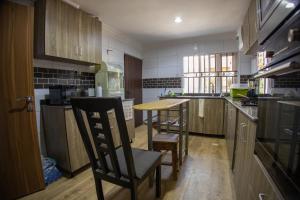 a kitchen with wooden cabinets and a table and chairs at Home away from Home. in Galadima