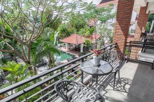 balcón con mesa, sillas y piscina en Angkor Eden Boutique Hotel en Siem Reap