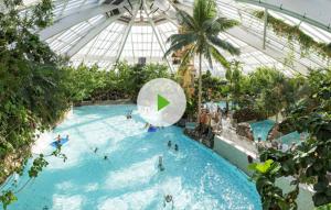a swimming pool in a building with people in it at cosy@sea in Middelkerke