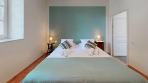 Una cama grande en una habitación con dos velas. en Domaine Paul Huc, en Fabrezan