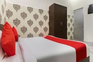 Bhiwāni的住宿－OYO Shree Shyam Roseberry Hotel And Restaurant，卧室配有带红色枕头的白色床
