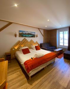 um quarto com uma cama, uma cadeira e um sofá em Hôtel du Grand-Mont em Beaufort