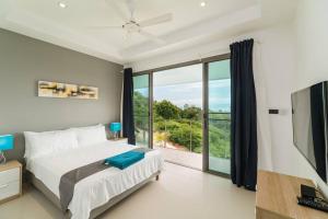 a bedroom with a bed and a large window at Villa 7 chambres vue mer in Ban Khlong Mae Nam +41 photos