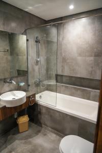 a bathroom with a sink and a tub and a toilet at Modern Heights in Juffair