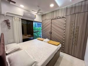 a bedroom with a large bed and a sliding door at La Alba 1 BHK Serviced Apartment in Mumbai