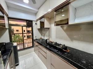 a kitchen with a stove top on a counter at La Alba 1 BHK Serviced Apartment in Mumbai