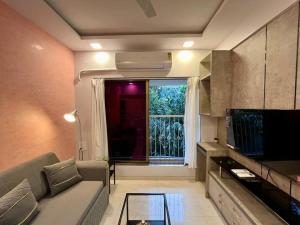 a living room with a couch and a window at La Alba 1 BHK Serviced Apartment in Mumbai