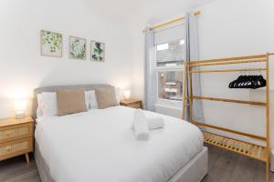 Un dormitorio con una gran cama blanca y una ventana en Flatzy - Stunning Home by Lark Lane with Pool Table, en Liverpool