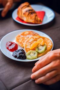 un piatto di pancake e frutta su un tavolo di Hotel Torre della Vittoria 1928 a Ferrara