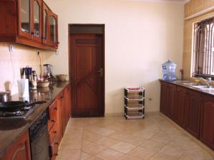 a kitchen with wooden cabinets and a door and a sink at Nareto House in Arusha