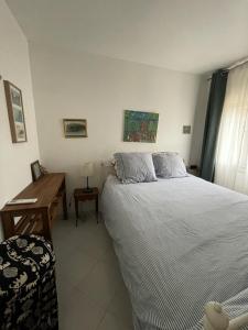 een slaapkamer met een groot bed en een bureau bij Villa Provencale au bord de mer in Martigues