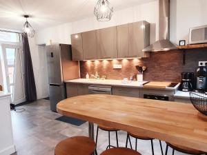 eine Küche mit einem Holztisch und einer Arbeitsplatte in der Unterkunft Gîte de Palesne - Pierrefonds in Pierrefonds