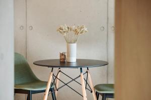 una mesa con un jarrón de flores. en Rise - Penthouse Suite with Terrace en Luxemburgo