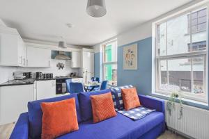 a living room with a blue couch and a kitchen at Beautiful Boutique Apartments in Central Bristol in Bristol