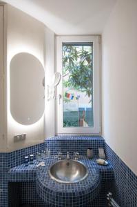 baño con lavabo y ventana en Urban Retreat - AmbrogioHost, en Bolonia