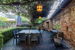 un patio con mesa, sillas y sombrilla en Le Clos Lamouroux - Grande maison pour 12 en Agen