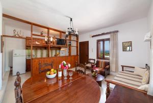 Il comprend une cuisine et un salon avec une table en bois. dans l'établissement Kounenos House, à Istron