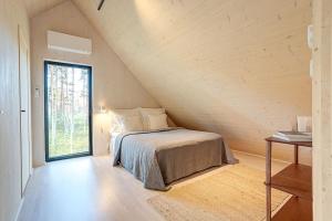 a bedroom with a bed in a attic with a window at Villa Pickala - Design - Seafront - Hot tub in Helsinki