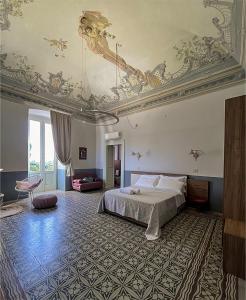 um quarto com uma cama e um tecto com pinturas em B&B Palazzo 1906 - Eco dimora storica em Bitetto