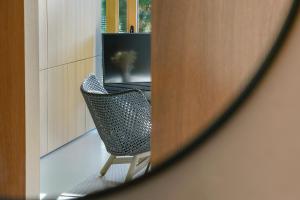 uno specchio che riflette una sedia in una stanza di Rise - Penthouse Suite with Terrace a Lussemburgo