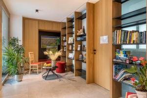 a library with bookshelves and a table in a room at Ferienwohnungen Karin - Lagrein in Termeno
