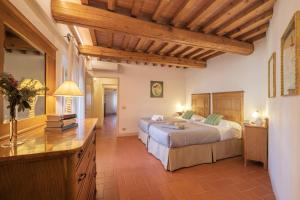 1 dormitorio con 2 camas y techo de madera en Casamaggio, en San Donato in Collina