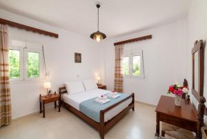 a bedroom with a bed and two tables and windows at Kounenos House in Istro