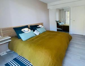a bedroom with a large bed with blue pillows at L'Hallali à la Baule centre in La Baule