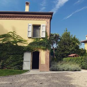 una casa gialla con una porta e una finestra di Antico Podere San Luca a Bologna