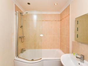 uma casa de banho com um chuveiro, uma banheira e um lavatório. em Pass the Keys Perfectly located 1 bed flat em Cardiff