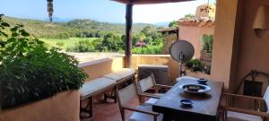 a balcony with a couch and a table and a view at Cava di Volpe , Case Del Golf Pevero, Costa Smeralda in Abbiadori