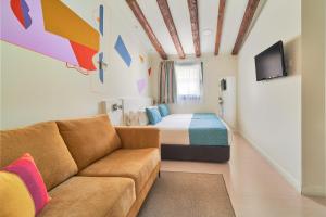 sala de estar con cama y sofá en una habitación en Blume Cruz Suites, en Madrid