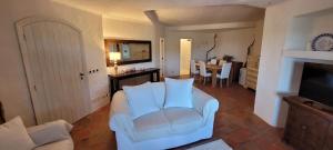 a living room with a white chair and a table at Cava di Volpe , Case Del Golf Pevero, Costa Smeralda in Abbiadori