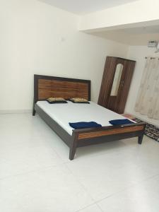 a bedroom with a large bed with a wooden headboard at Sai Leela Guest House in Dabolim
