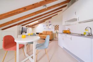 a kitchen and dining room with a white table and chairs at Blume Cruz Suites in Madrid