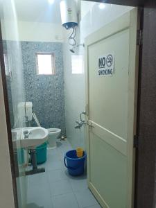 a bathroom with a toilet sink and a no smoking sign at Sai Leela Guest House in Dabolim