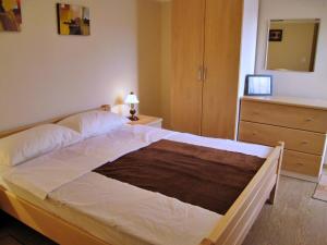 a bedroom with a large bed with a dresser and a dresser at Apartments Vila Nidisa in Čižići