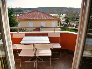 uma varanda com uma mesa e cadeiras e uma vista em Apartments Vila Nidisa em Čižići