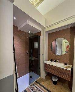 y baño con lavabo y ducha con espejo. en B&B Palazzo 1906 - Eco dimora storica, en Bitetto