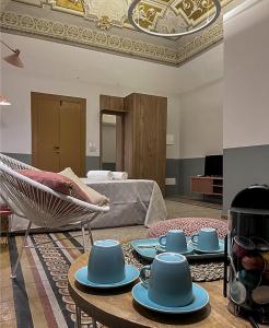 una sala de estar con tazas azules y platillos en una mesa en B&B Palazzo 1906 - Eco dimora storica, en Bitetto