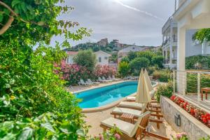 Una piscina con sillas y sombrillas al lado de un edificio. en Villa Mari, en Kas