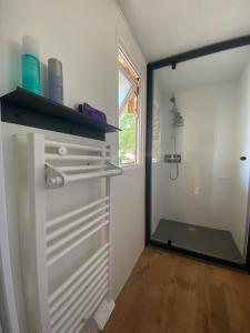 a bathroom with a closet with a glass door at Camping de la Liez in Peigny