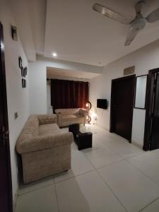 a living room with a couch and a table at 2 Bedrooms Standard Apartment Islamabad-HS Apartments in Islamabad