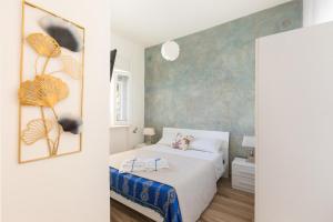ein Schlafzimmer mit einem weißen Bett und einer blauen Wand in der Unterkunft Villino delle Orchidee by BarbarHouse in Sant'Isidoro