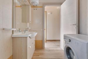 ein Badezimmer mit einem Waschbecken und einer Waschmaschine in der Unterkunft Villino delle Orchidee by BarbarHouse in Sant'Isidoro