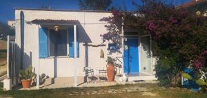 una pequeña casa blanca con puertas azules y flores en La collina sui trabocchi, en Ortona