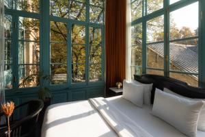 a bedroom with a bed and a large window at Unfound Door - Design Hotel in Tbilisi City